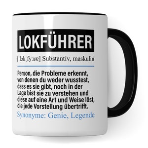 Pode incluir: Uma caneca de cerâmica branca com interior e alça pretos. A caneca apresenta a palavra alemã "LOKFÜHRER" em letras pretas em negrito, juntamente com uma definição e sinónimos. A caneca é uma ideia de presente humorística.