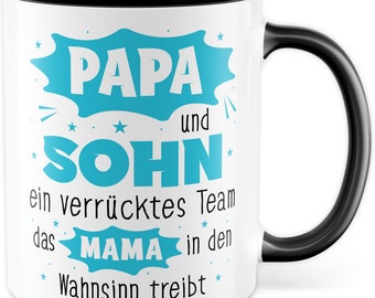 Può includere: Tazza in ceramica bianca con bordo e manico neri. La tazza ha un design blu che dice "Papa und Sohn ein verrücktes Team das Mama in den Wahnsinn treibt".