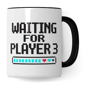 Op de afbeelding: Witte keramische koffiemok met een zwarte rand en handvat. De mok heeft een gepixelde afbeelding met de tekst "WAITING FOR PLAYER 3" en daaronder een bijna volle voortgangsbalk. De voortgangsbalk heeft blauwe, roze en zwarte gepixelde hartjes.