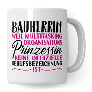 Könnte beinhalten: Weiße Keramiktasse mit schwarzem Text, der "Bauherrin weil multitasking organisations Prinzessin keine offizielle Berufsbezeichnung ist" in Pink lautet.