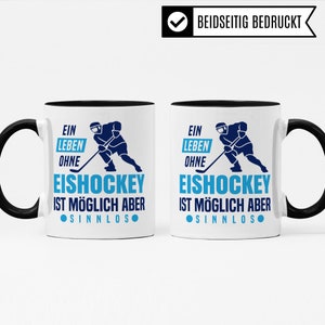 Pu&ograve; includere: Una tazza da caff&egrave; bianca con un bordo e un manico neri. La tazza presenta una grafica blu e nera di un giocatore di hockey con il testo "Ein Leben Ohne Eishockey Ist M&ouml;glich Aber Sinnlos" su entrambi i lati.