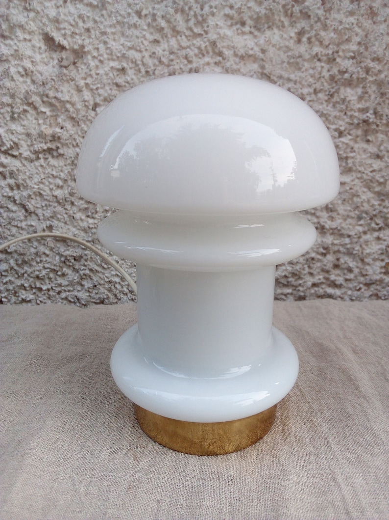 May include: White glass table lamp with a mushroom-shaped shade and a gold base.