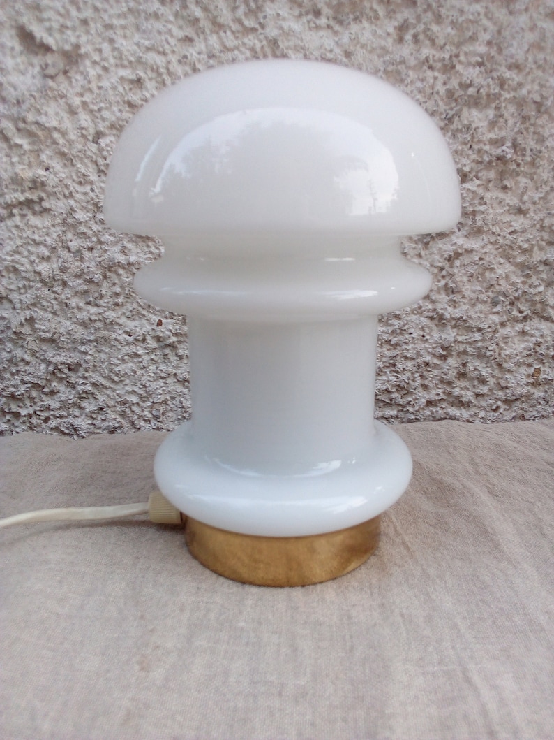 May include: White ceramic table lamp with a mushroom-shaped shade and a gold base.