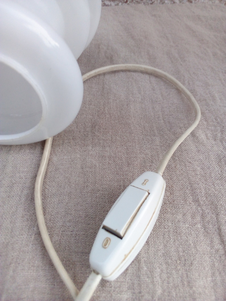 May include: A white lamp with a cord and an inline on/off switch. The switch is a rocker style with a white plastic casing.