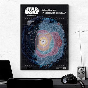 May include: A framed Star Wars Galaxy Map poster. The map shows a colourful depiction of the galaxy, with the text "A long time ago in a galaxy far, far away..." and "Star Wars Galaxy Map". The poster is in a black frame.
