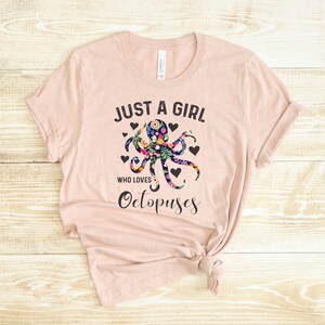 Puede incluir: Una camiseta rosa con el texto "Just a girl who loves Octopuses" y un dise&ntilde;o de pulpo floral.