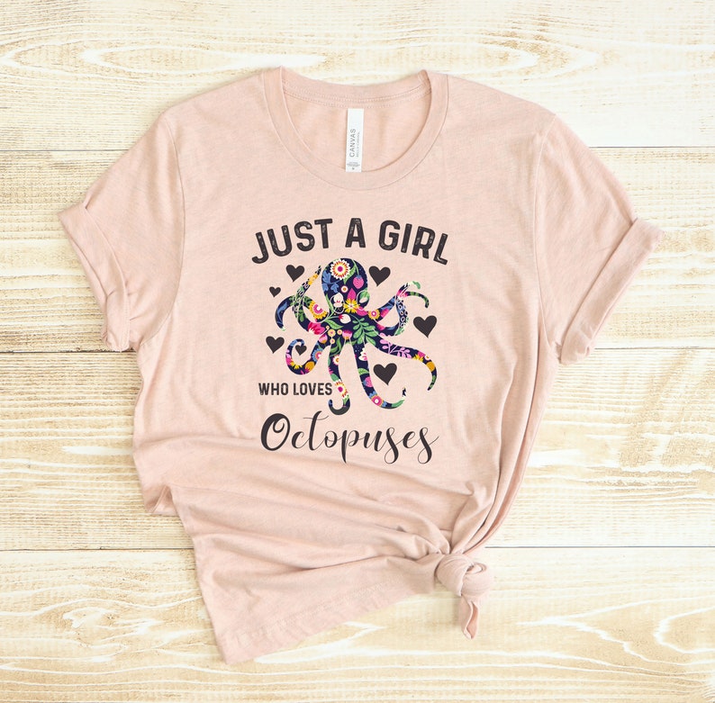 Puede incluir: Una camiseta rosa con el texto "Just a girl who loves Octopuses" y un dise&ntilde;o de pulpo floral.