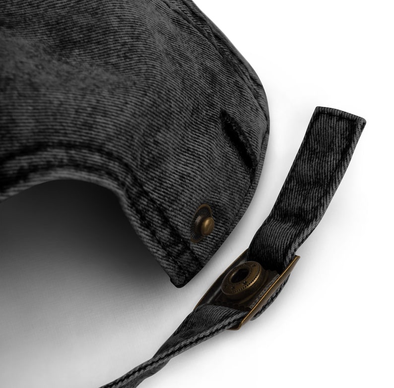 May include: A black denim baseball cap with a strap and a brass buckle closure.