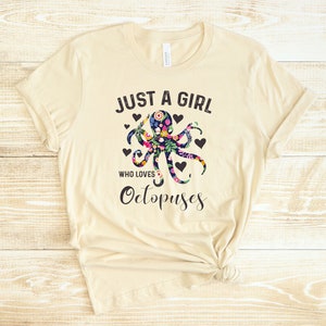 Puede incluir: Una camiseta beige con un dise&ntilde;o de pulpo floral y el texto "Just a girl who loves Octopuses".