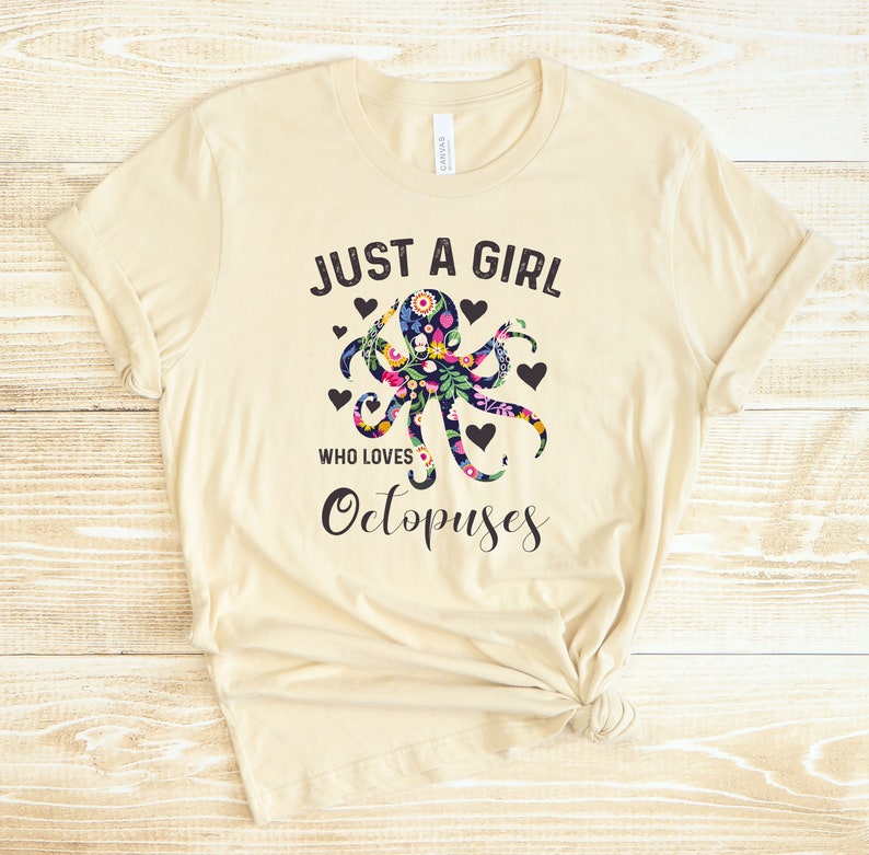 Puede incluir: Una camiseta beige con un dise&ntilde;o de pulpo floral y el texto "Just a girl who loves Octopuses".
