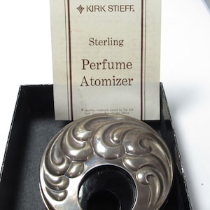 May include: A sterling silver perfume atomizer with an ornate, swirling design. The atomizer is in a black box with a card that reads "KIRK STIEFF Sterling Perfume Atomizer."