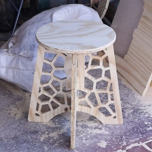 Könnte beinhalten: Ein Hocker aus Holz mit einem Wabenmuster und einer runden Oberseite. Der Hocker ist aus hellem Holz gefertigt und hat eine natürliche Oberfläche.