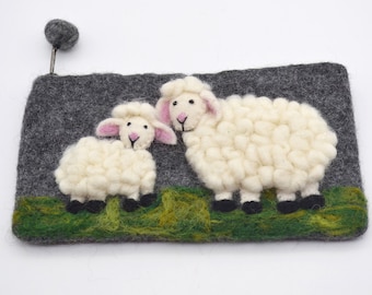 May include: A gray felt pouch featuring two fluffy white sheep with pink ears and black hooves, standing on green felt grass. The pouch has a gray felt background and a small gray ball attached to a metal pin.