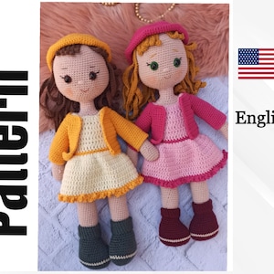 Peut inclure: Deux poupées en crochet avec des cheveux en laine. Une poupée porte une robe et une veste jaunes, l'autre porte une robe et une veste roses. Les deux poupées portent des bottes brunes.