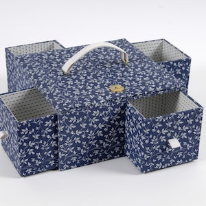 May include: A blue and white floral patterned storage box with a white handle and four drawers. The box has a floral pattern and a white handle.