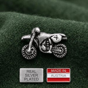 Puede incluir: Un pin de motocicleta de color plateado con el número 4 en el lateral. El pin está junto a una etiqueta rectangular que dice "REAL SILVER PLATED" y un pin con la bandera austriaca y las palabras "MADE IN AUSTRIA".