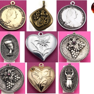 May include: A collection of ten silver and gold pendants with various designs, including a heart with an edelweiss flower, a grapevine with a pink gem, a beetle, and a woman's profile. The pendants are all made in Germany.