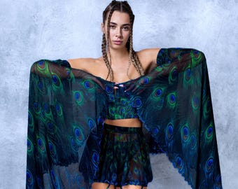 Peut inclure: Un ensemble transparent bleu foncé avec un motif de plumes de paon. La tenue comprend un crop top, une jupe et un châle fluide. Le motif de plumes de paon incorpore des nuances de vert et de bleu.