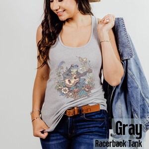 May include: Gray racerback tank top with a graphic of a frog playing a guitar in a field of flowers.