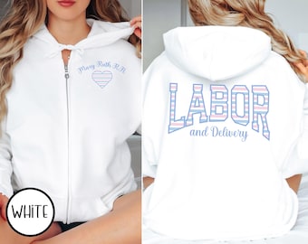 May include: White zip-up hoodie with "Mary Ruth R.N." and a heart design on the front. The back features the words "LABOR and Delivery" in blue and pink striped letters. A casual, comfortable garment.