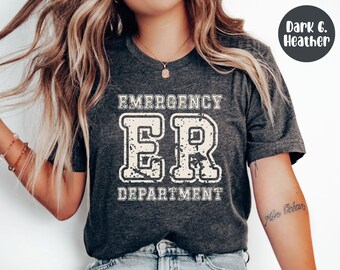 May include: Dark heather gray t-shirt with the text "EMERGENCY ER DEPARTMENT" in a distressed, off-white font. The shirt is a crew neck style.