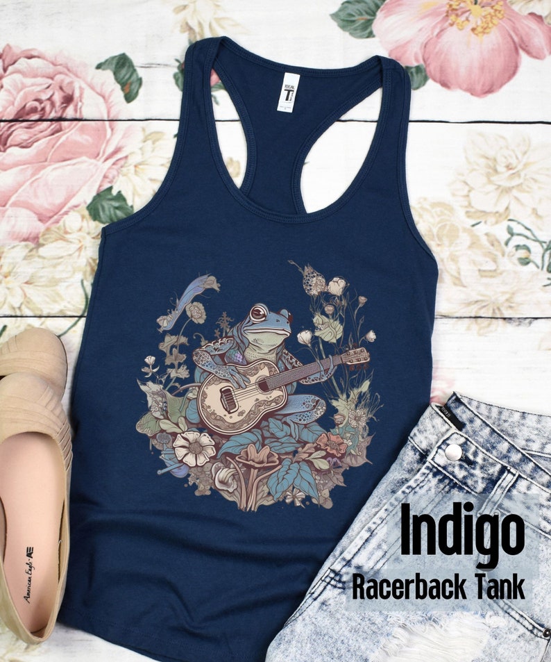 May include: Indigo racerback tank top with a blue frog playing a guitar in a floral design.