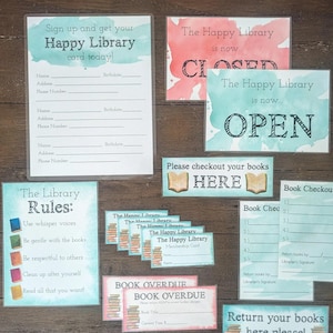 May include: A set of printable signs for a classroom library. The signs are decorated with watercolor-style backgrounds in shades of blue and pink. The signs include "The Happy Library is now Open", "The Happy Library is now Closed", "The Library Rules", "Book Checkout List", "Book Overdue", and "Return your books here please".