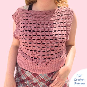 Op de afbeelding: Een oudroze gehaakte top met een brede boothals, mouwloos ontwerp en een herhalend opengewerkt patroon. Het kledingstuk heeft een geribbelde zoom en bevat een cirkelvormige afbeelding in de hoek met de tekst PDF Crochet Pattern.