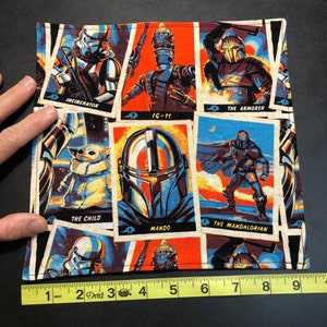 Puede incluir: Un art&iacute;culo de tela cuadrada con un collage de personajes de Star Wars al estilo c&oacute;mic. Los personajes incluyen a The Mandalorian, The Child e IG-11. El art&iacute;culo mide aproximadamente 23 cm de ancho.