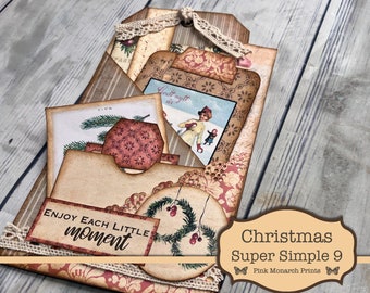 May include: A Christmas-themed paper craft project with a vintage aesthetic. The project features a variety of patterned papers, embellishments, and a sentiment that reads "Enjoy Each Little Moment".