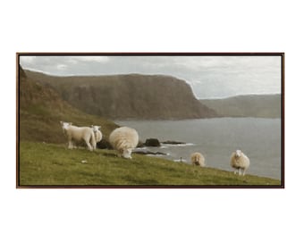 May include: A scenic landscape painting depicting a rocky cliffside overlooking a calm body of water. Five white sheep graze on a grassy hillside in the foreground.