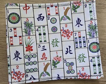 May include: A square fabric textile featuring a repeating pattern of Mahjong tiles. The off-white tiles display various traditional symbols, including Chinese characters, bamboo stalks, floral motifs, and numbered circles in red, green, and blue ink.