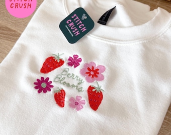Felpa girocollo bianca con ricamo floreale "Berry Blooms" e fragole primaverili.