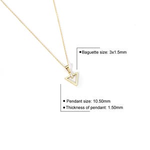 Puede incluir: Un collar dorado con un colgante triangular. El colgante mide 10,50 mm de tama&ntilde;o y 1,50 mm de grosor, con una baguette de 3x1,5 mm. El collar se muestra sobre un fondo blanco.