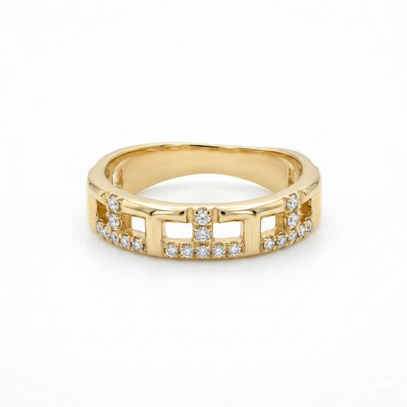 Puede incluir: Un anillo de oro con un dise&ntilde;o geom&eacute;trico. El anillo presenta cortes rectangulares y est&aacute; adornado con peque&ntilde;as gemas brillantes. La banda tiene un acabado liso y pulido, y el dise&ntilde;o es moderno y elegante. El anillo mide aproximadamente 1,5 cm de ancho.