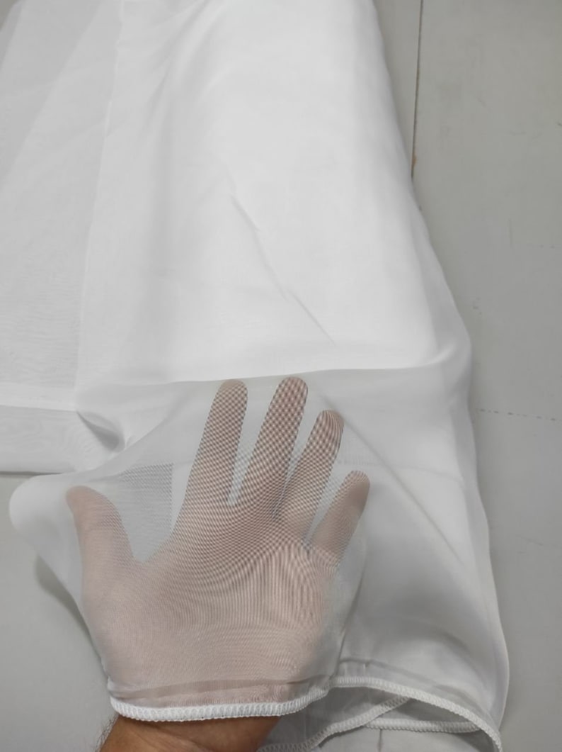 May include: White sheer fabric with a delicate, fine mesh texture. The fabric is soft and lightweight, with a subtle sheen.