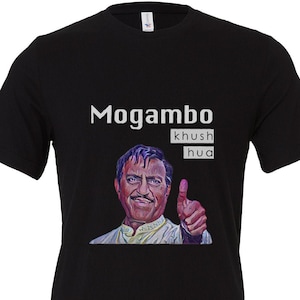 May include: Black t-shirt featuring a colorful portrait of a man giving a thumbs-up, with the words "Mogambo khush hua" in white text above the image. The shirt is made of a soft material.