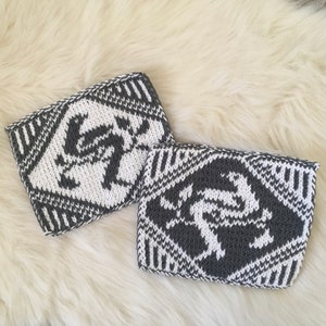 May include: Two knitted fabric squares with a geometric pattern in white and grey. The pattern features a stylised design of a crab.