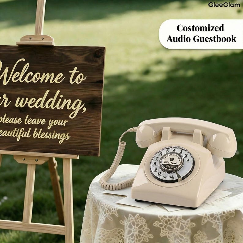 May include: A cream-colored vintage rotary phone sits on a lace-covered table. The phone has a circular dial and a coiled cord. A wooden sign with the words "Welcome to our wedding" is in the background. The text "Costomized Audio Guestbook" is also visible.