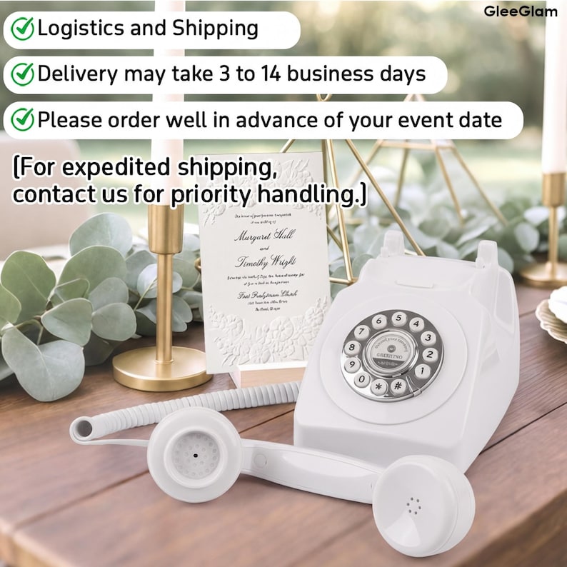 May include: A white vintage rotary phone with a silver dial and a matching handset on a wooden surface. A wedding invitation is propped up behind the phone. The image also includes a gold candle holder and greenery.