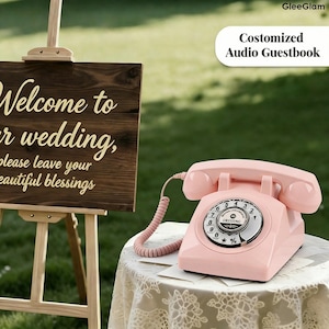 May include: A pink rotary phone with a coiled cord sits on a lace-covered table. The phone has a circular dial and is labeled "Costomized Audio Guestbook". A wooden sign on an easel reads "Welcome to your wedding, please leave your beautiful blessings."
