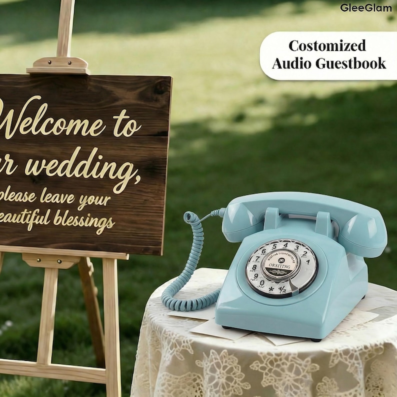May include: A light blue vintage telephone with a rotary dial sits on a lace-covered table. The phone is a classic design, with a curved handset and a coiled cord. The text "Costomized Audio Guestbook" is visible.