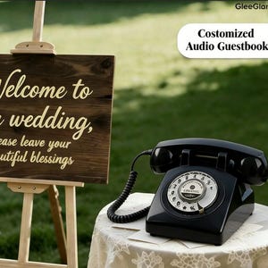 May include: A black vintage rotary phone sits on a lace-covered table next to a wooden sign that reads "Welcome to our wedding, please leave your beautiful blessings." The sign is on an easel. The text "Costomized Audio Guestbook" is also visible.