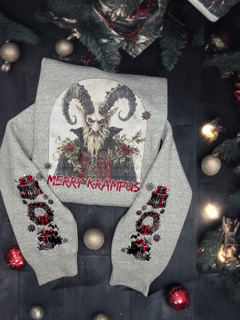 May include: A gray sweatshirt with a black and white illustration of Krampus on the front. The sleeves have a black and red illustration of a wreath with a gift box. The text "Merry Krampus" is printed on the front of the sweatshirt.