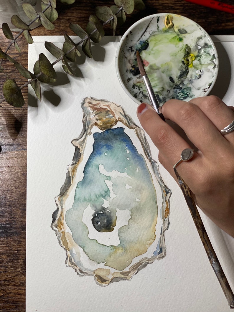 May include: A watercolor painting of an oyster shell with a blue, green, and brown color scheme. The shell is painted on a white background.