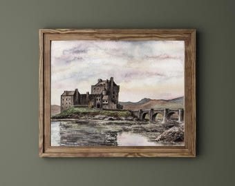 May include: Watercolor painting of a castle on a small island, connected to the mainland by a stone bridge. The artwork is framed in a natural wood frame, with a serene sky and water reflection.