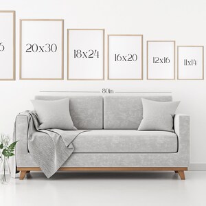 May include: A white wall with a gray couch and a set of framed prints in various sizes. The prints are labeled with their dimensions in inches, starting with 24x36 and decreasing in size. The couch is 80 inches wide.