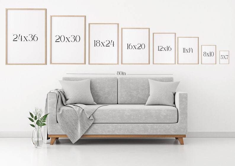 May include: A white wall with a gray couch and a set of framed prints in various sizes. The prints are labeled with their dimensions in inches, starting with 24x36 and decreasing in size. The couch is 80 inches wide.