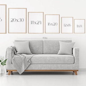 K&ouml;nnte beinhalten: Ein hellgraues Sofa mit einer Decke und zwei Kissen, positioniert unter einer Reihe von acht rechteckigen Rahmen in verschiedenen Gr&ouml;&szlig;en mit der Beschriftung 24x36, 20x30, 18x24, 16x20, 12x16, 11x14, 8x10 und 5x7 Zoll, mit einer Ma&szlig;linie f&uuml;r 80 Zoll.