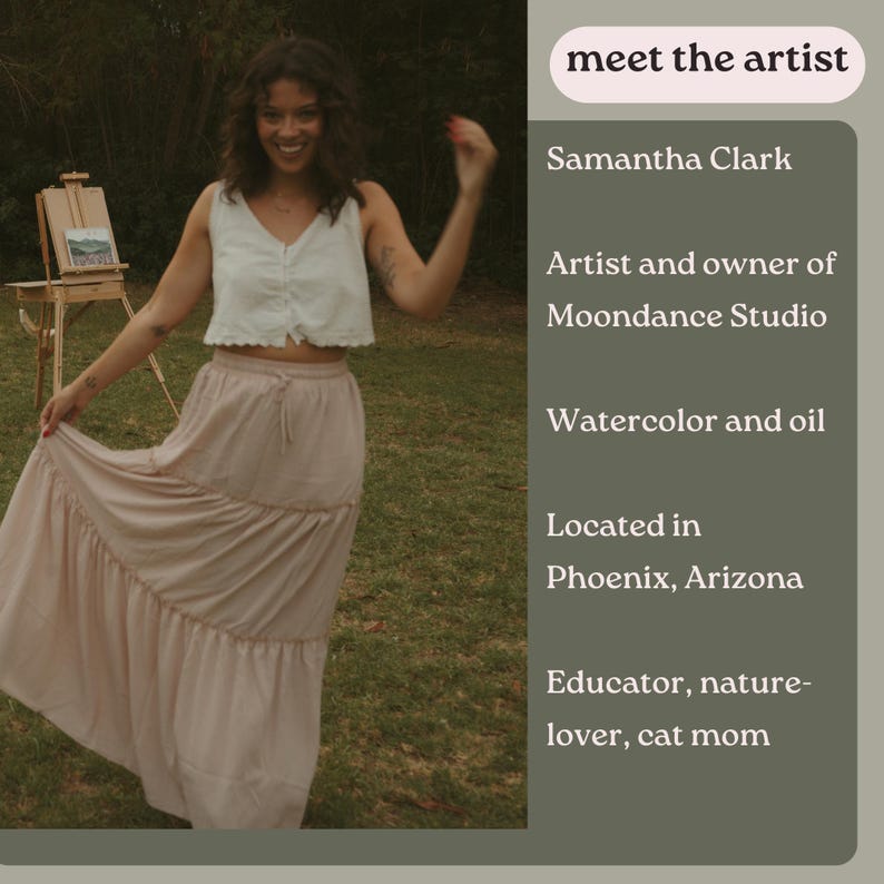 May include: A woman wearing a white tank top and a long pink skirt stands in a grassy field. She is smiling and holding her hand up in the air. Behind her is a small easel with a painting on it. The text "meet the artist" is at the top of the image, followed by "Samantha Clark". The text continues with "Artist and owner of Moondance Studio", "Watercolor and oil", "Located in Phoenix, Arizona", and "Educator, nature-lover, cat mom".